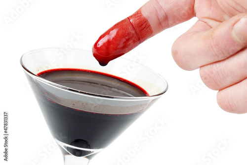 Bloody finger with glass full of cow blood