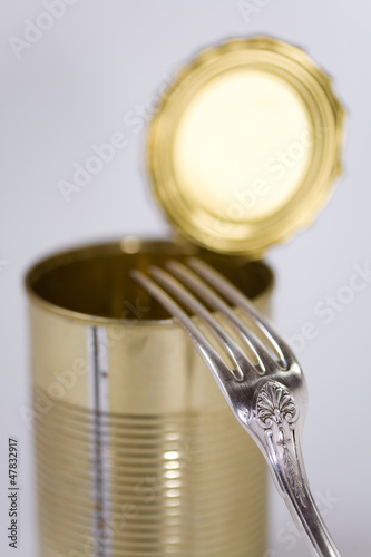 boîte de conserve vide et fourchette en argent