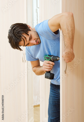 man repairing the door handle furniture