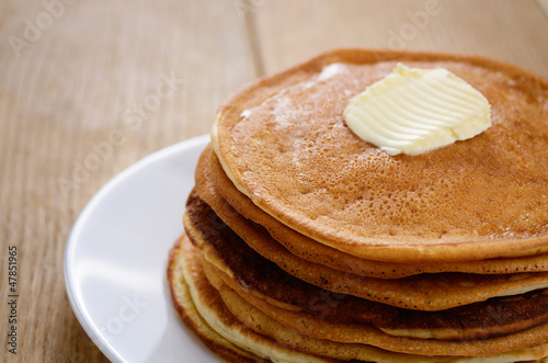 White plate with pankakes stack on the wooden table photo