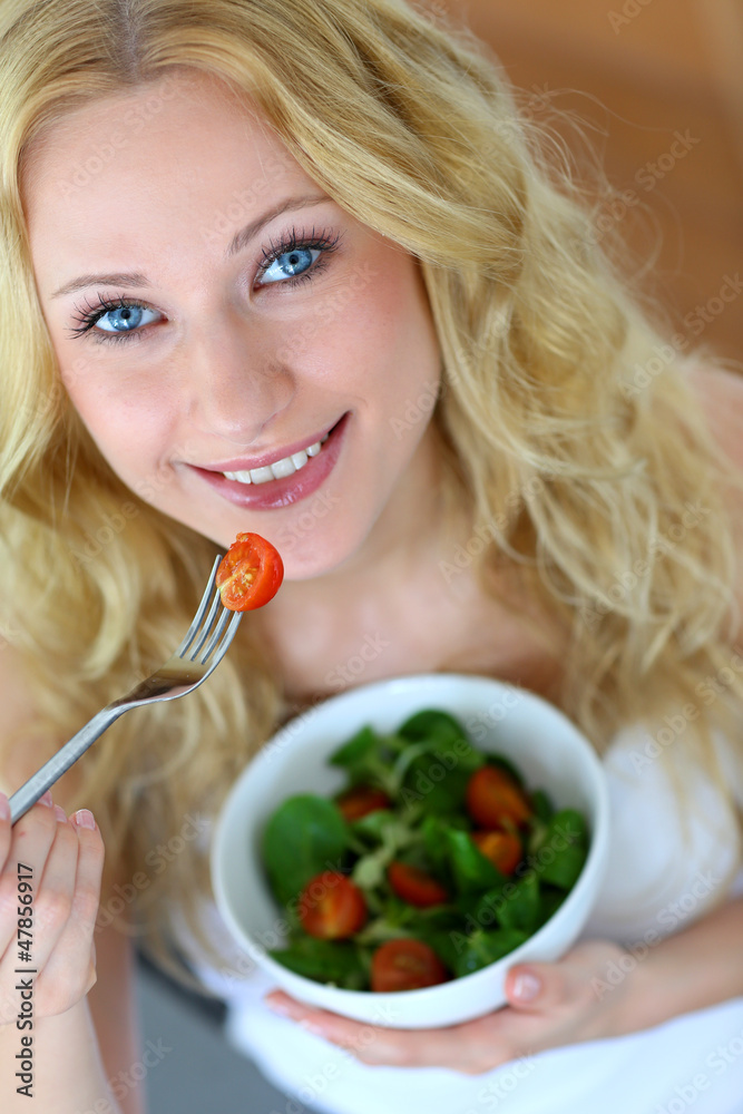 Beautiful blond woman eating fresh salad Beautiful blond woman eating fresh salad