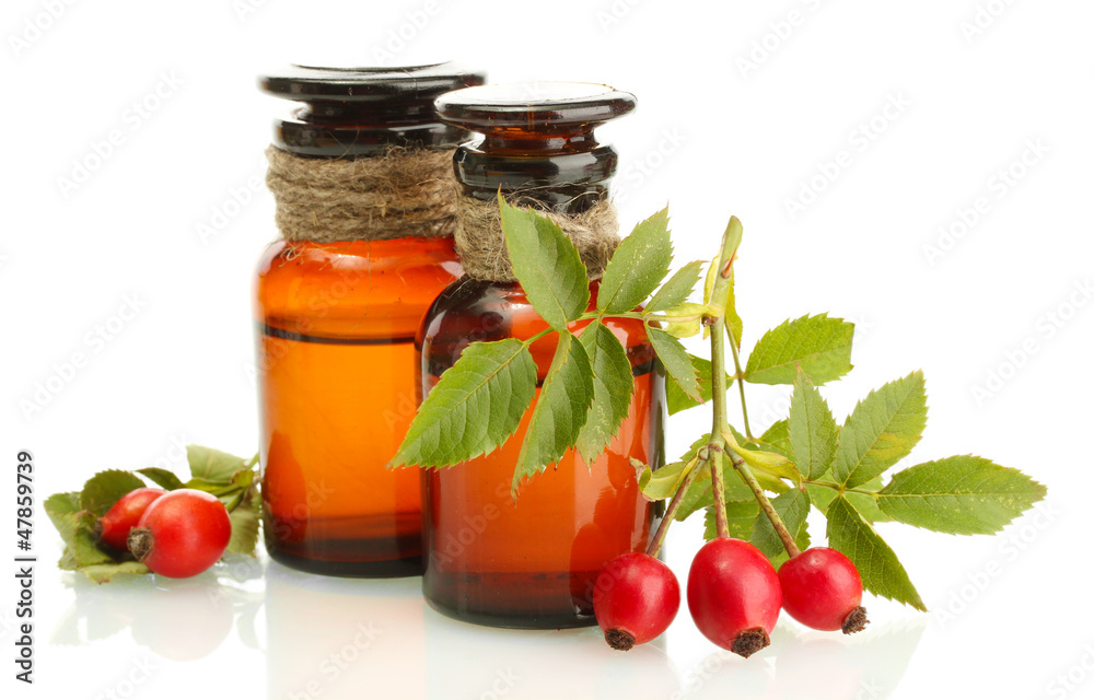 Obraz premium medicine bottles with hip roses, isolated on white