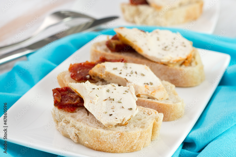 toasts with tomato and chicken on the plate