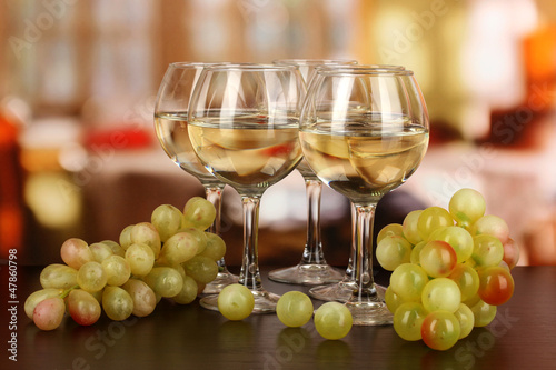 White wine in glass on room background