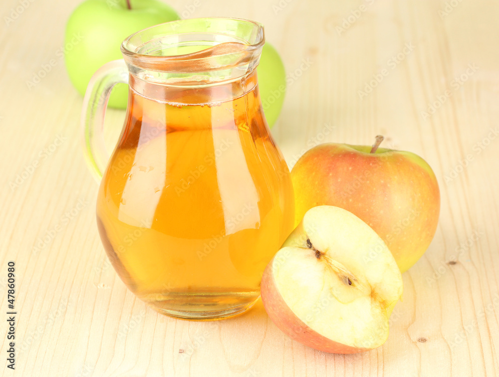 Full jug of apple juice and apple on wooden background Full jug of apple juice and apple on wooden background