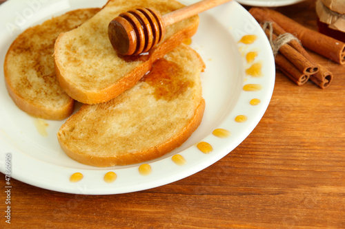 White bread toast with honey on wooden table