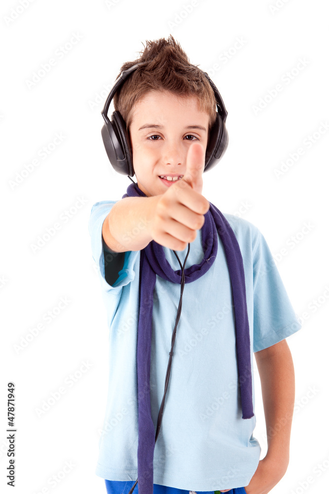 Cute little boy enjoying music using headphones and showing thum Cute little boy enjoying music using headphones and showing thum