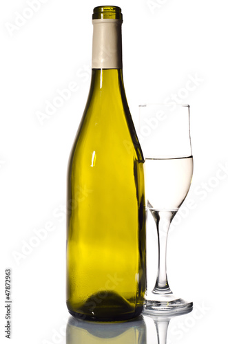 Bottle of white wine and glass over light grey background