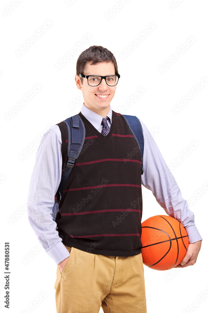 Smiling male student with school bag holding a basketball