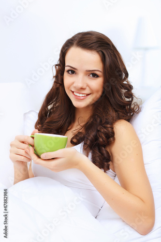 Young woman having cup of tea at home