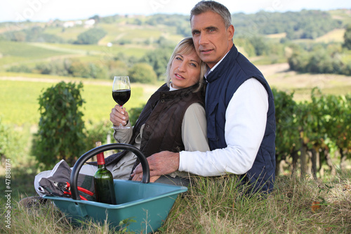 Couple drinking wine by vineyard