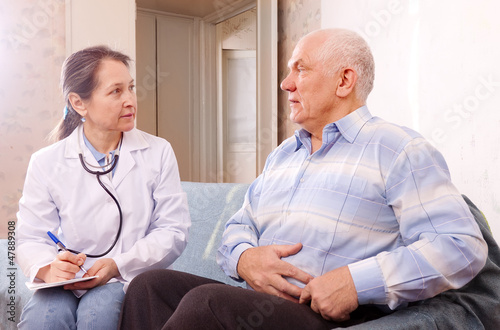 man complaining  to doctor about stomachache photo