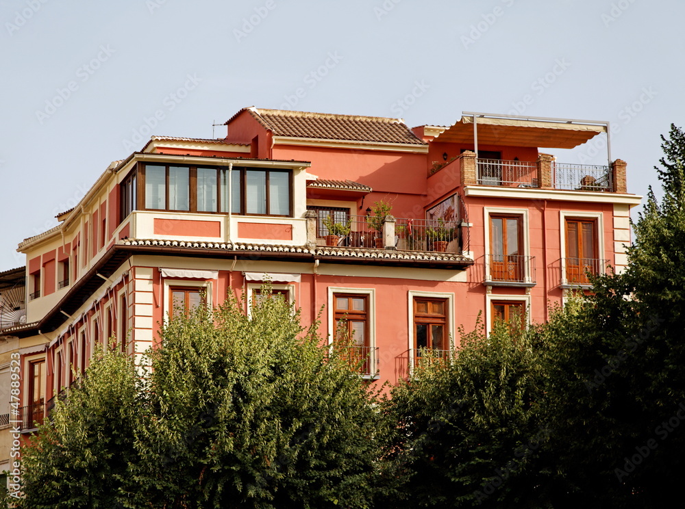 Maison rose avec terrasse.