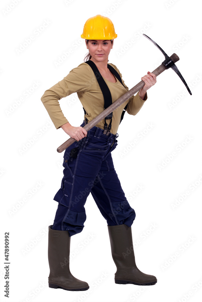 Female construction worker posing with pick-ax Female construction worker posing with pick-ax