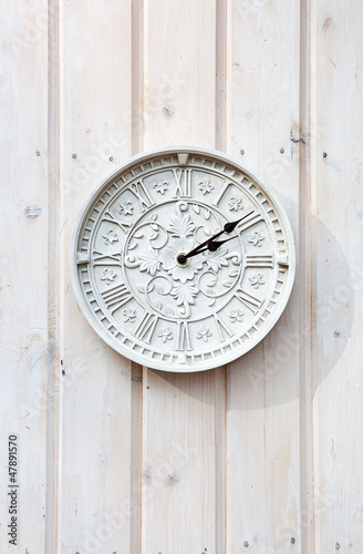 White clock on a wooden wall