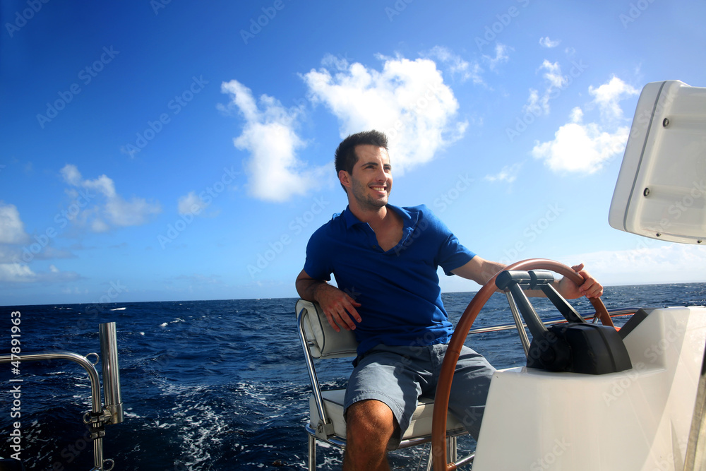 Obraz premium Smiling young sailor navigating in Caribbean sea