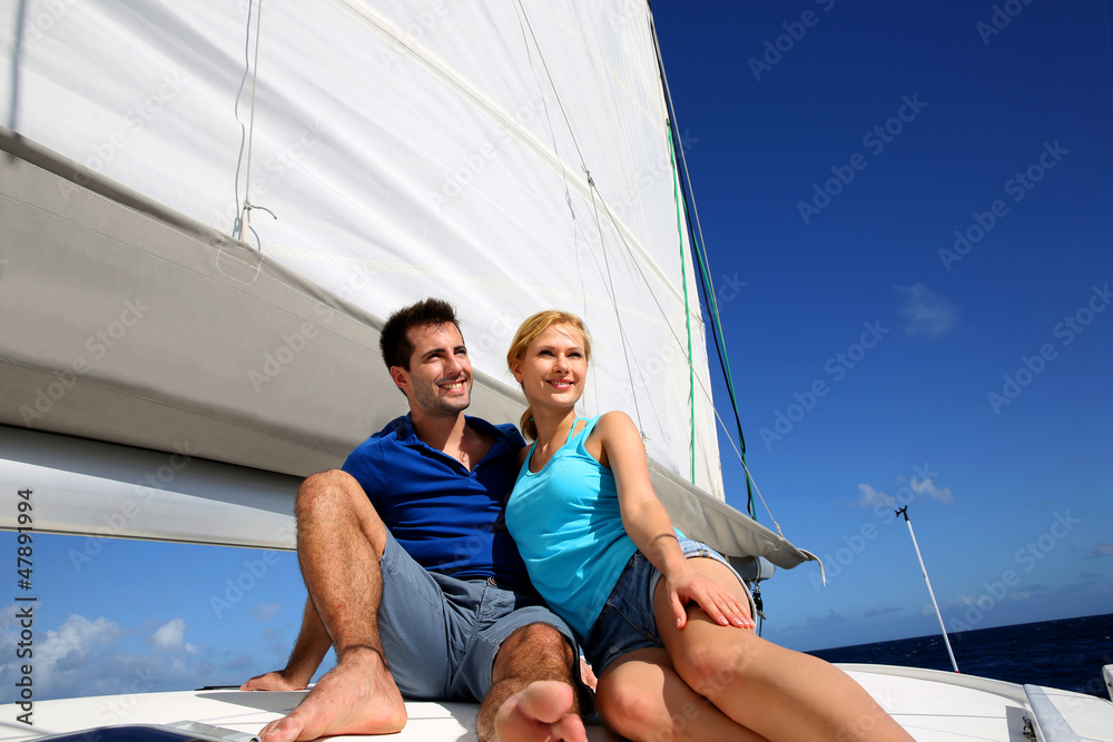 Portrait of couple sitting on the top of sailing boat