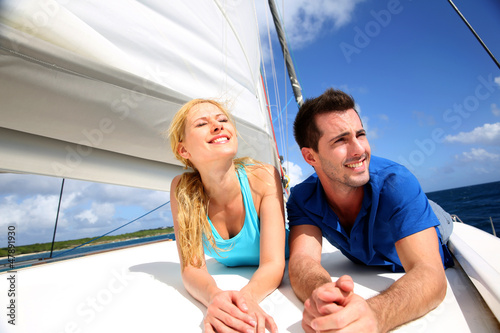 Smiling couple relaxing on a yacht by sunny day