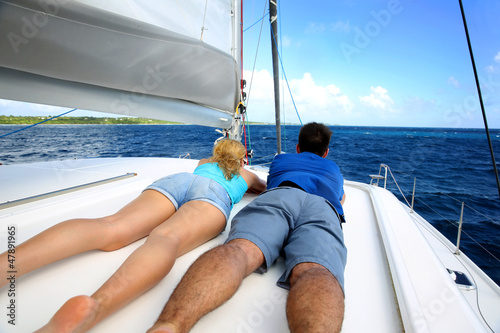 Couple relaxing on a sailing boat while cruising