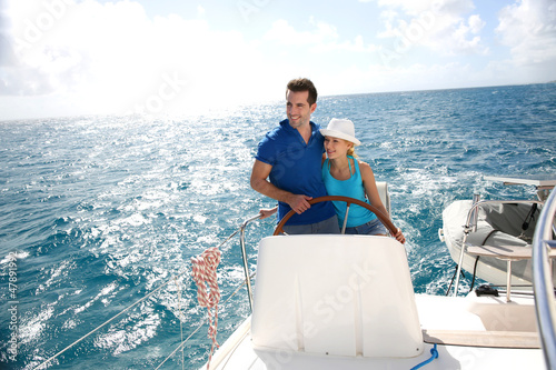 Young couple navigating on a yacht in caribbean sea © goodluz