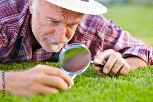 Close up of senior gardener cutting grass