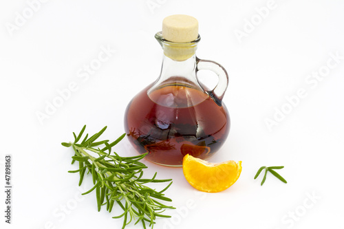 Bottle of liquor with rosemary & mandarin segment