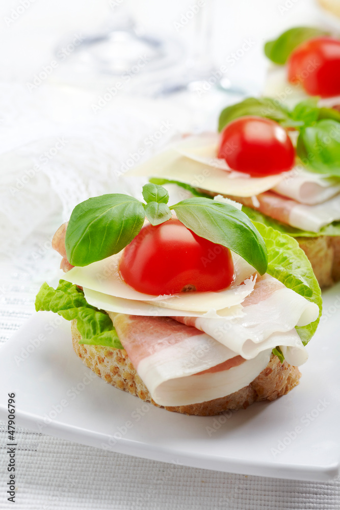 Sandwich with prosciutto, parmesan cheese and tomato Sandwich with prosciutto, parmesan cheese and tomato