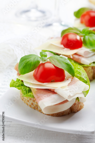 Sandwich with prosciutto, parmesan cheese and tomato