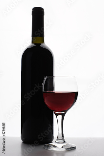 Bottle of red wine with glass