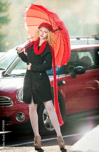 Obraz na płótnie Beautiful fashionable young girl with red umbrella in the street w salonie