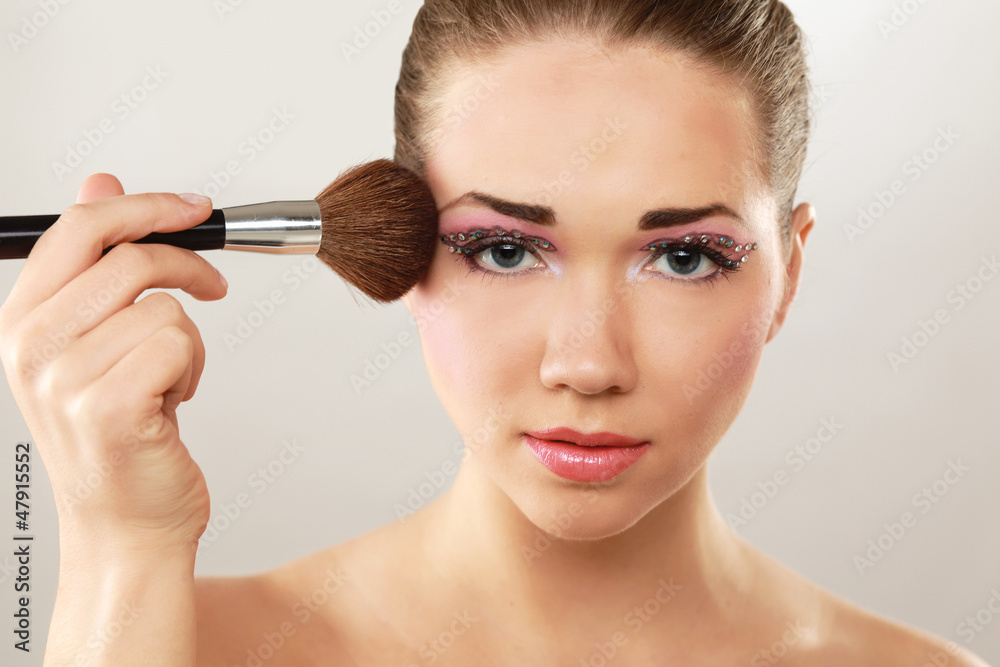 A beautiful young woman doing make-up A beautiful young woman doing make-up