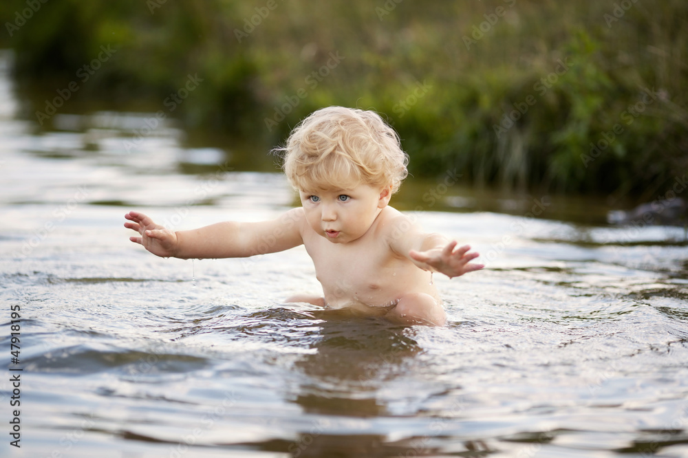 Fototapeta premium little funny boy playing in water