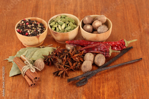 Nutmeg and other spices on wooden background