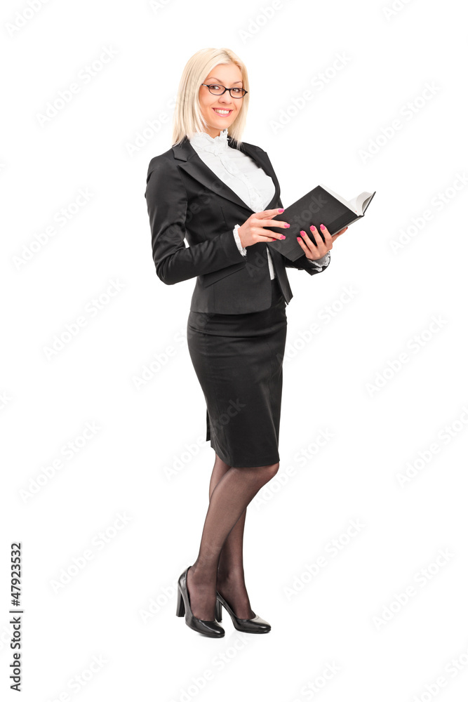Full length portrait of a blond female teacher holding a book Full length portrait of a blond female teacher holding a book