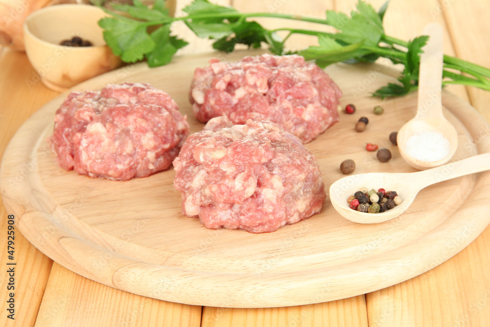 Raw meatballs with spices on wooden table Raw meatballs with spices on wooden table