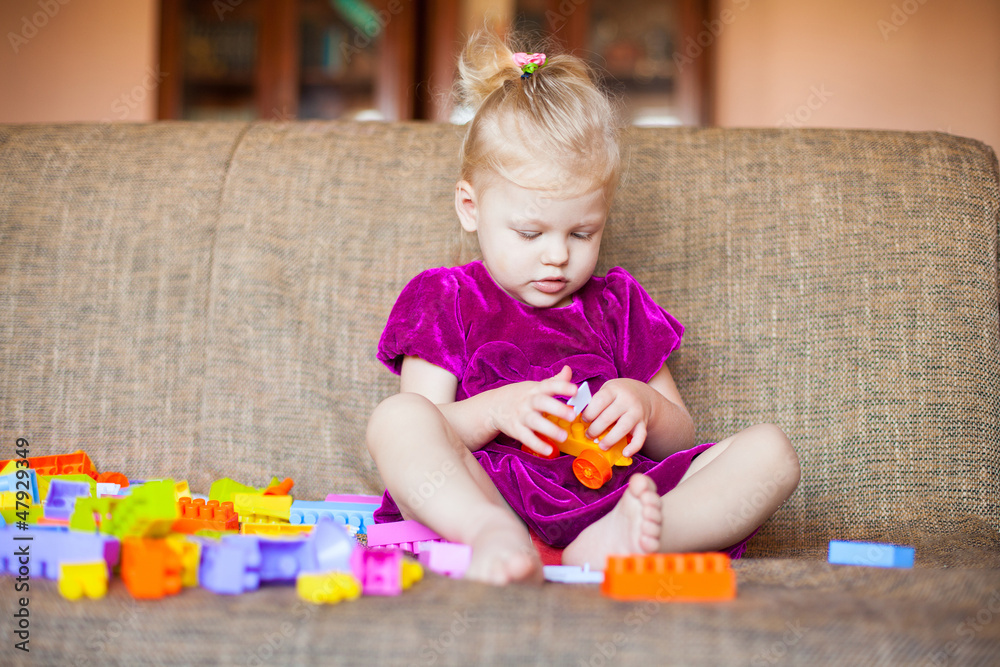 Cute little girl playing with blocks on the couch. Series Cute little girl playing with blocks on the couch. Series