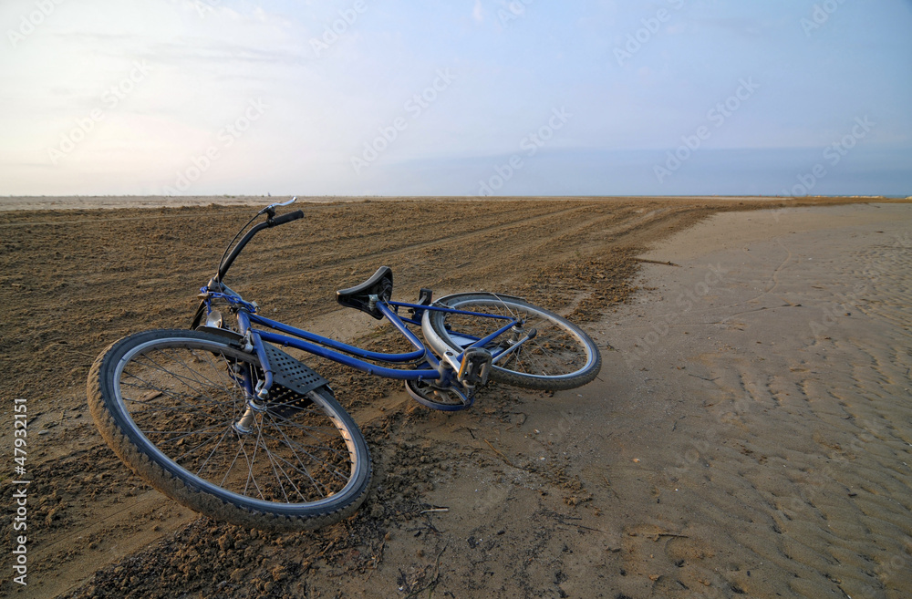 Fototapeta premium Abandoned bicycle along an empty beach