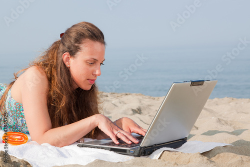 Woman Working at Computer on the Beach