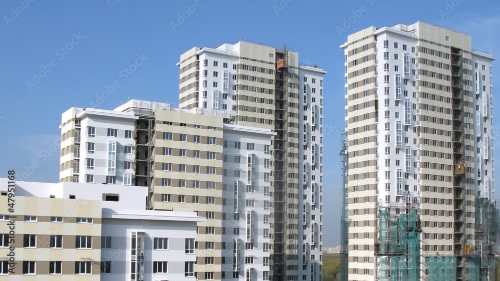 Many new buildings with building lifts stand under blue sky Many new buildings with building lifts stand under blue sky