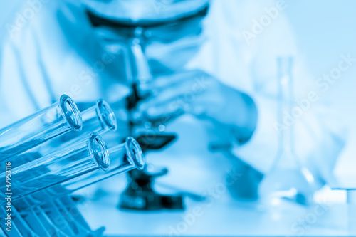 laboratory assistant working with a microscope in lab