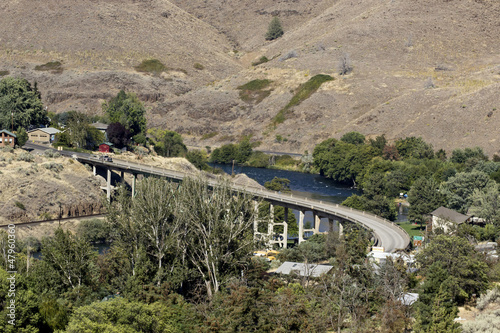 Curved highway bridge though river valley photo