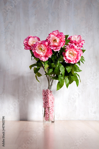 Bouquet of peonies in a vase against a blue wall. Interior. © Yarkovoy