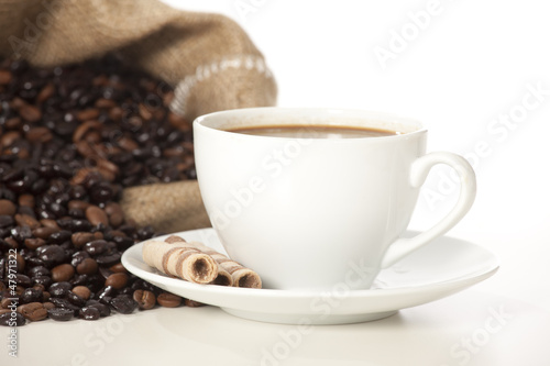 Cup of black coffee and beans isolated on white