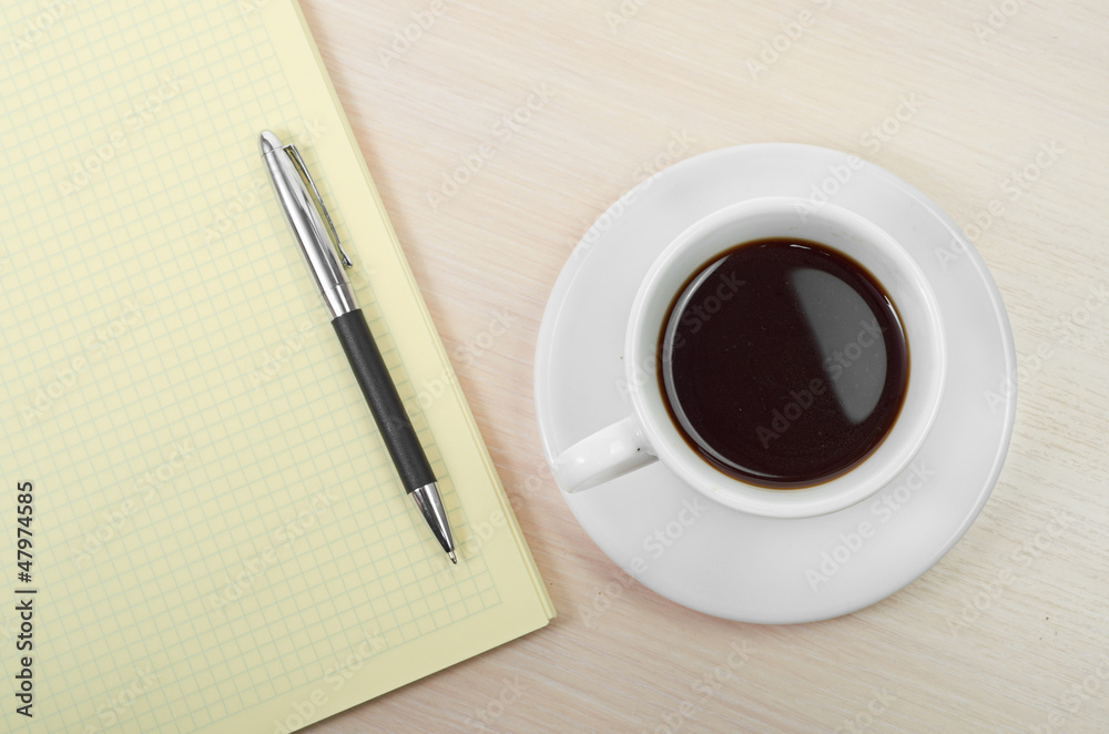 Coffee cup with note book on table Coffee cup with note book on table