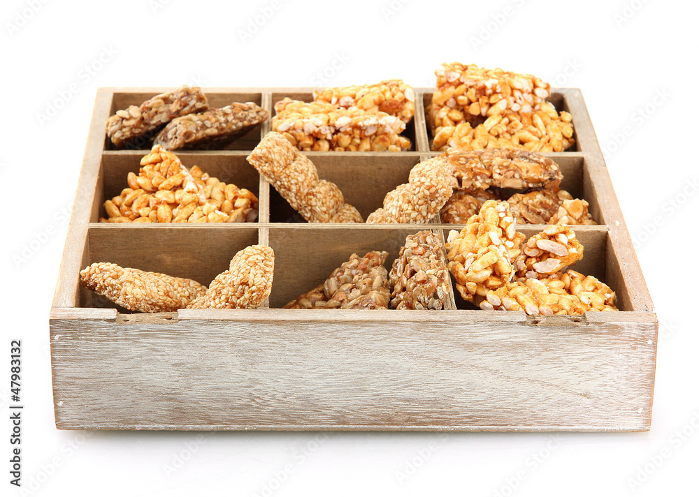 tasty sweets (kozinaki)in wooden crate, isolated on white tasty sweets (kozinaki)in wooden crate, isolated on white