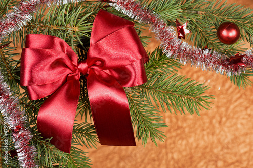 fir branches with red bow on golden background