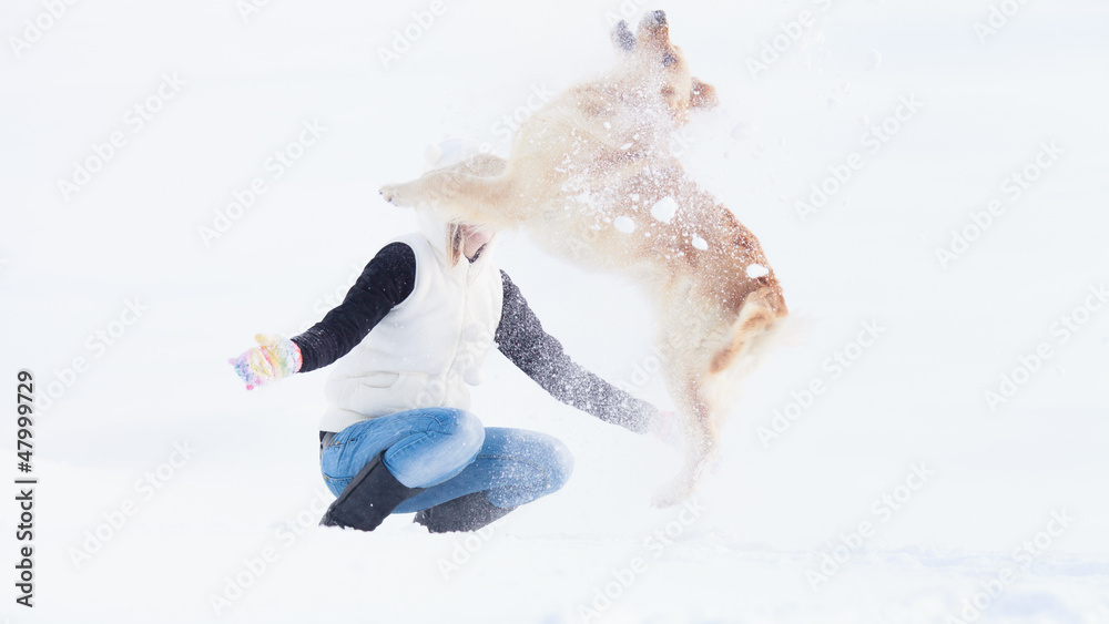 Girl with her dog playing in winter outdoors