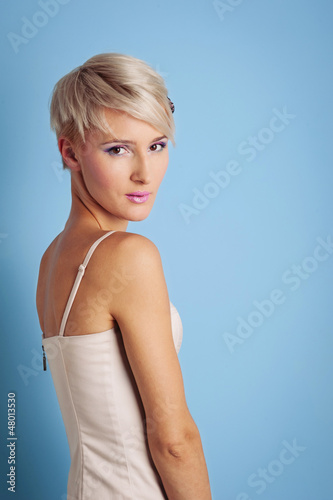 Young woman portrait over blue background.
