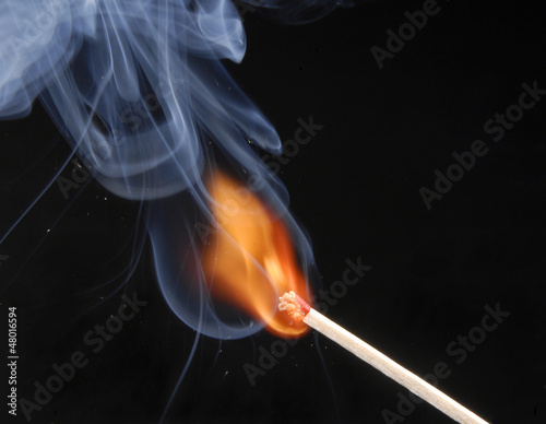 Tableau sur toile Encendiendo un cerillo,fósforo encendido en fondo negro.