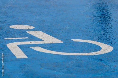 Blue handicap parking or wheelchair accessible sign in parking.